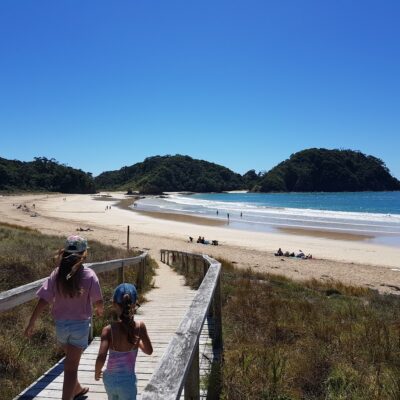 Two kids walking down to the beach at Matapouri Bay