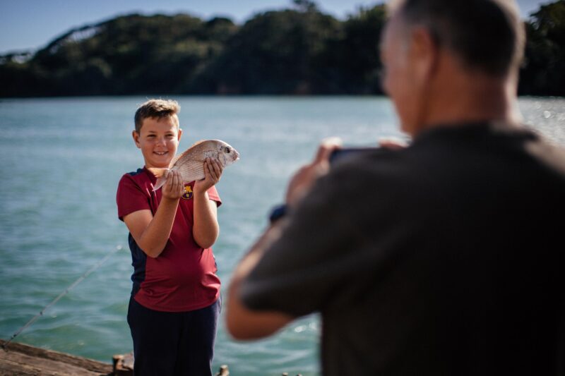Boy holding a Snapper he caught while fishing